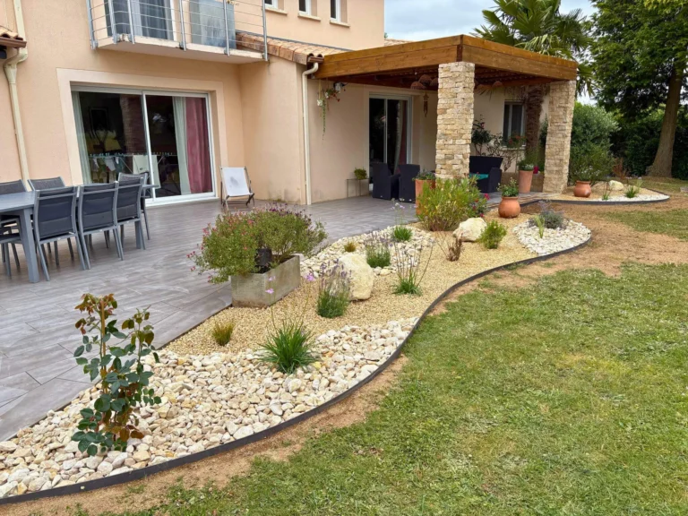 Réalisation d’un massif décoratif avec plat acier, plantation de vivaces et arbustes, et mise en place de graviers calcaire dans la Vienne